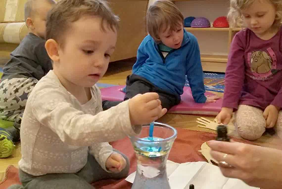 Ciocia z grupą dzieci podczas zabawy ruchowej w sali żłobka